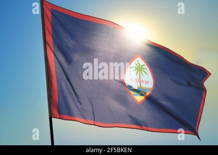 Bandiera di Guam sventolando sul vento davanti al sole Foto Stock