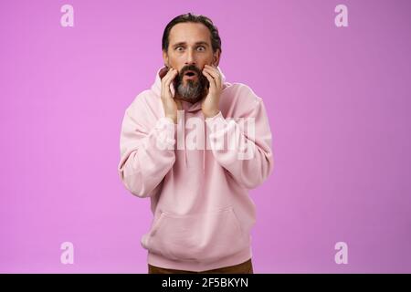 Impressionato sorpreso bello adulto bearded uomo capelli grigi assistere barbiere negozio non può credere vedere il proprio riflesso diventare elegante tocco di tendenza Foto Stock