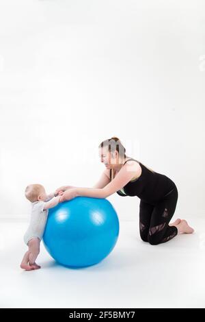 Madre con bambino divertirsi con palla ginnica Foto Stock