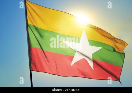 Bandiera del Myanmar che sventola sul vento di fronte al sole Foto Stock