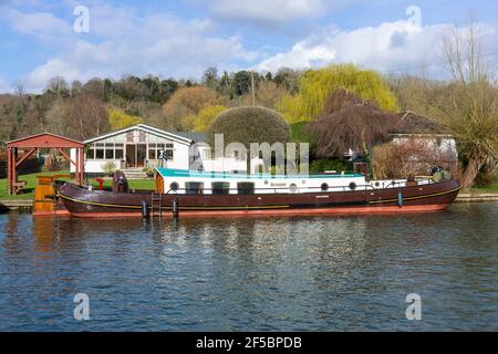 Dutch Torque ormeggiato fuori da una casa sul fiume Rod Eyot Island vicino a Henley-on-Thames, Oxfordshire, Inghilterra, Regno Unito Foto Stock