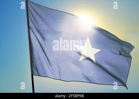 Bandiera somala sventolando sul vento davanti al sole Foto Stock