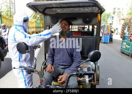 Nuova Delhi, India. 25 Marzo 2021. Un operatore sanitario raccoglie un tampone da un pilota di risciò automatico per un test COVID-19 alla periferia di Nuova Delhi, India, il 25 marzo 2021. Il COVID-19 dell'India ha raggiunto 11,787,534 il giovedì come 53,476 nuovi casi sono stati segnalati da tutto il paese, il più alto quest'anno, secondo le ultime cifre rilasciate dal ministero federale della salute. Credit: Parta Sarkar/Xinhua/Alamy Live News Foto Stock