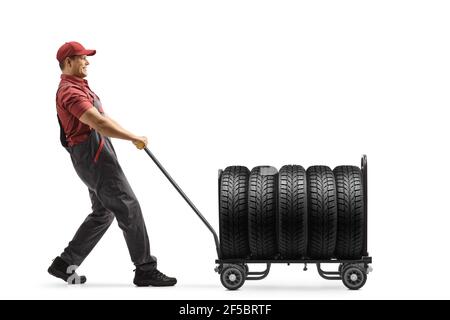 Operatore che tira un autocarro a mano caricato con pneumatici isolati su sfondo bianco Foto Stock