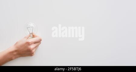 La mano femmina contiene una lampadina a incandescenza Foto Stock