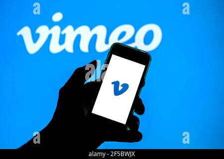 In questa illustrazione fotografica l'app Vimeo visualizzata sullo schermo di uno smartphone e il logo Vimeo sullo sfondo. Foto Stock