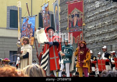 Un uomo vestito in costume d'epoca legge da un proclama in una festa medievale a Montevarchi, Italia Foto Stock