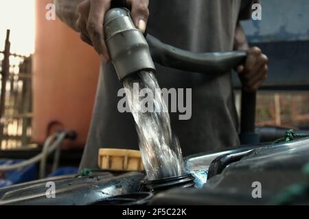 Un itinerante che riempie le taniche di jerry con acqua dolce in una stazione di rifornimento di acqua a Rorotan, Giacarta del nord, Jakarta, Indonesia. La stazione è fornita da Aetra, uno dei fornitori di acqua della città. I dati sulla qualità dell'acqua sono molto importanti, secondo le indicazioni dell'ONU Water nel loro Summary Progress Update 2021 pubblicato il 1 marzo 2021 a Ginevra. "La generazione, la convalida, la standardizzazione e lo scambio di informazioni dei dati creeranno fiducia in modo che i leader possano prendere decisioni informate e aumentare la responsabilità", afferma il rapporto. Foto Stock