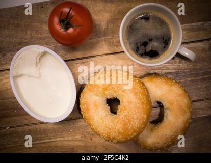 Bagel freschi con formaggio cremoso su un tavolo per la colazione Foto Stock