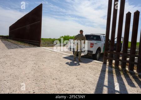 Una sezione del muro di confine tra il Texas e il Messico rimane incompiuta nella contea di Hidalgo, mentre un membro della Guardia Nazionale pattugliò nelle vicinanze il 25 marzo 2021. La maggior parte dei lavori si fermò sul muro di confine dopo l'inaugurazione del Pres. Statunitense Joe Biden il 20 gennaio 2021. Credit: Bob Daemmrich/Alamy Live News Foto Stock