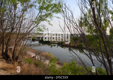 Roma, Texas, USA 25 marzo 2021. Il ponte internazionale tra Roma, Texas e Ciudad Miguel Aleman in Messico si estende sul Rio Grande relativamente tranquillo il 25 marzo 2021. La zona è regolarmente sorvegliata da diverse forze dell'ordine e delle forze dell'immigrazione grazie al suo facile accesso al fiume nella contea di Starr, Texas. Credit: Bob Daemmrich/Alamy Live News Foto Stock