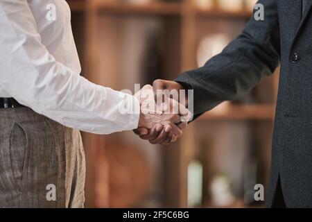 Primo piano di uomini d'affari si salutano a vicenda scuotendo le mani ufficio Foto Stock