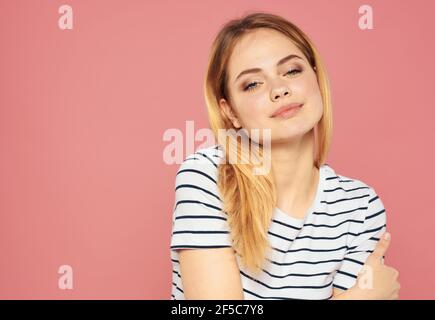 Ritratto di una bionda affascinante su sfondo rosa in una t-shirt modello romanticismo vista ritagliata Foto Stock