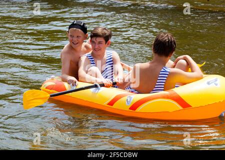 Tre bambini in barca gonfiabile, i bambini che si divertono in estate in acqua Foto Stock