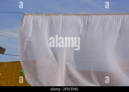 soffiare la tenda bianca all'aperto come tema di separazione o privacy Foto Stock
