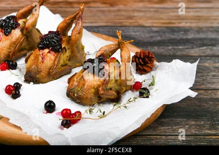 Quaglia fritto. Su sfondo di legno. tacchino piccolo. Primo piano Foto Stock