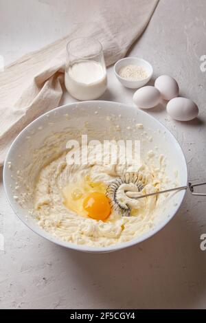 Ciotola con formaggio spalmabile e uova per impastare l'impasto. Ingredienti per cucinare basco spagnolo bruciato Saint Sebastian cheesecake. Crema di formaggio, zucchero, uova, Foto Stock