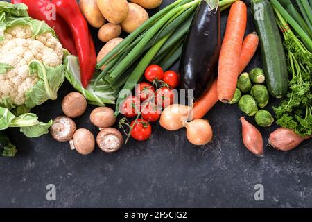 Varie verdure sane su uno sfondo di ardesia grigio scuro, concetto di cibo per dieta di idoneità e perdere peso, spazio di copia, vista ad angolo alto dall'alto, sel Foto Stock