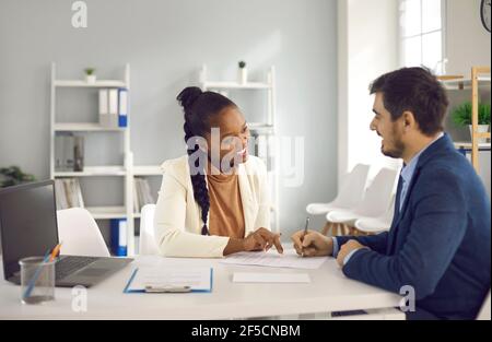 L'intermediario assicurativo americano africano spiega i dettagli del contratto al cliente cuacasiano Foto Stock