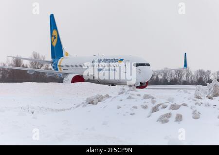 Ucraina, Kiev - 12 febbraio 2021: Aerei in inverno. Velivolo. C'è molta neve all'aeroporto. Cattive condizioni meteorologiche e visibilità. Blocchi di neve. Nevicate. C'è molta neve all'aeroporto. Foto Stock