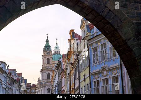 Distretto di Mala Strana a Praga, Repubblica Ceca. Una vista della via Mostecka con la Chiesa di San Nicola sullo sfondo da sotto la fine Foto Stock