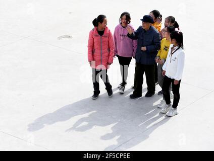 (210326) -- HEFEI, 26 marzo 2021 (Xinhua) -- Yan Mingyou parla con studenti che una volta hanno ricevuto il sostegno finanziario da Yan alla scuola primaria di Fuxing a Zhuwan Township della contea di Dingyuan, Chuzhou City, Provincia di Anhui della Cina orientale, 23 marzo 2021. Yan Mingyou, 92 anni, è ancora al posto dell'insegnamento della musica nelle scuole elementari rurali. Ritirandosi come insegnante rurale nel 1990, Yan si è offerto di insegnare musica agli studenti delle scuole rurali. Nel 1953, Yan lasciò l'esercito e tornò alla sua città natale, la Zhuwan Township, nella contea di Dingyuan. Ha rinunciato ad un lavoro migliore al governo locale e ha scelto w Foto Stock