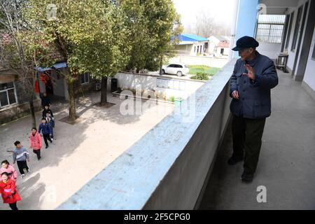 (210326) -- HEFEI, 26 marzo 2021 (Xinhua) -- Yan Mingyou ondeggia agli studenti che arrivano per frequentare la sua lezione di musica alla Fuxing Primary School di Zhuwan Township della Contea di Dingyuan, Chuzhou City, Provincia di Anhui, 23 marzo 2021. Yan Mingyou, 92 anni, è ancora al posto dell'insegnamento della musica nelle scuole elementari rurali. Ritirandosi come insegnante rurale nel 1990, Yan si è offerto di insegnare musica agli studenti delle scuole rurali. Nel 1953, Yan lasciò l'esercito e tornò alla sua città natale, la Zhuwan Township, nella contea di Dingyuan. Ha rinunciato ad un lavoro migliore al governo locale e ha scelto di lavorare nelle zone rurali Foto Stock