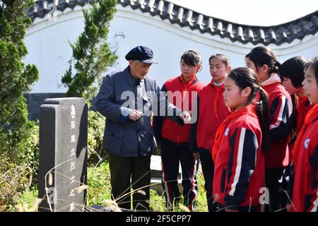 (210326) -- HEFEI, 26 marzo 2021 (Xinhua) -- Yan Mingyou presenta la storia dei martiri agli studenti della scuola elementare di Zhuwan al cimitero dei martiri a Zhuwan Township della contea di Dingyuan, Chuzhou City, provincia di Anhui, 24 marzo 2021. Yan Mingyou, 92 anni, è ancora al posto dell'insegnamento della musica nelle scuole elementari rurali. Ritirandosi come insegnante rurale nel 1990, Yan si è offerto di insegnare musica agli studenti delle scuole rurali. Nel 1953, Yan lasciò l'esercito e tornò alla sua città natale, la Zhuwan Township, nella contea di Dingyuan. Ha rinunciato ad un lavoro migliore al governo locale e ha scelto di WO Foto Stock