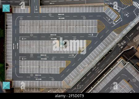 Parcheggio visto dall'alto, con file di auto parcheggiate e posti auto segnati che formano una scena urbana geometrica astratta. Foto Stock