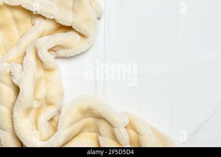 Mattina accogliente. Vista dall'alto della biancheria da letto bianca, soffici piumini beige con spazio fotocopie. Foto Stock