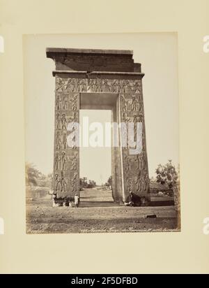 Karnak. Tempio di Ramessès IV. Porte triomphale. Vista su una porta monumentale scolpita con geroglifici. L'angolo in alto a destra del cancello sembra essere mancante. Due uomini nativi stanno accanto all'apertura del cancello. (Recto, stampa) in basso a destra, inscritto in negativo: '133. Karnak. Tempio di RamessËs IV. porte sic triomfale parzialmente troncato"; Foto Stock