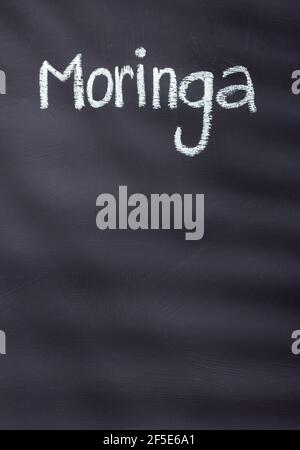 Moringa oleifera - Moringa scritto con gesso su sfondo rustico Foto Stock