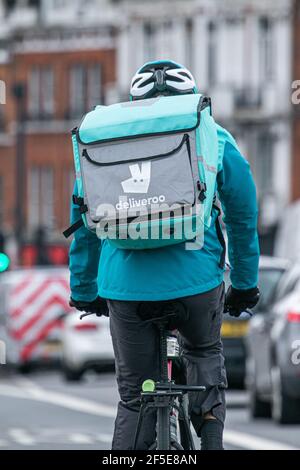 PUTNEY LONDON, REGNO UNITO 26 MARZO 2021. Piloti Deliveroo a Putney High Street. L'azienda di consegna di cibo Deliveroo sta preparando per una quotazione di mercato azionario di £8,8bn il 7 aprile ma alcune aziende di investimento del Regno Unito hanno espresso le preoccupazioni sui diritti dei lavoratori e sono esitanti non comprare Deliveroo shares.Deliveroo è un'azienda di consegna di cibo in linea fondata da William Shu in 2013 e opera in 200 sedi in tutto il Regno Unito. Credit amer Ghazzal/Alamy Live News Foto Stock