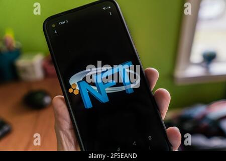 Andover, ma, US-24 marzo 2021: Persona che tiene il telefono con il logo NFT su di esso. Foto Stock