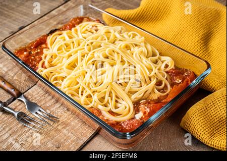 In forno, pasta feta arrosto con pomodori in teglia. Sfondo di legno. Vista dall'alto Foto Stock