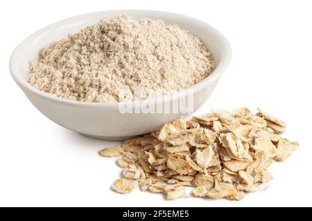 Farina di avena in una ciotola bianca di ceramica accanto ad un mucchio di avena di porridge non cotta isolata su bianco. Foto Stock