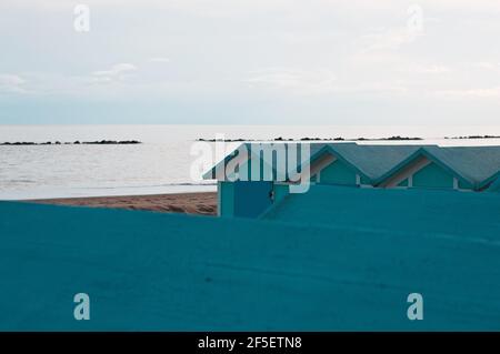 Una serie di capanne blu sulla costa mediterranea nelle ore serali (Pesaro, Marche, Italia) Foto Stock