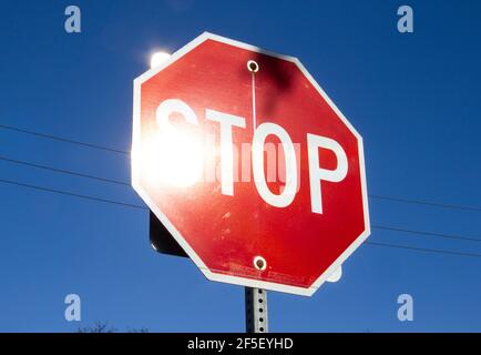 Il sole si riflette su un segnale di stop Foto Stock