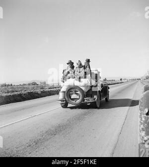 Otto persone correlate appena arrivati in questo roadster dal Texas. In cerca di occupazione come pickers di piselli. Negli Stati Uniti 80. Imperial Valley, California. 1939. Fotografia di Dorotea Lange. Foto Stock