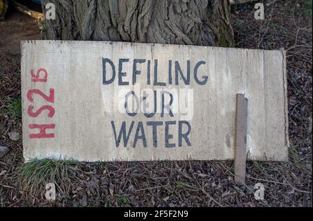 Uxbridge, Regno Unito. 19 febbraio 2021. Un HS2 defilando il nostro segno d'acqua al campo di protesta di Harvil Road Anti HS2. HS2 hanno distrutto acri di campagna vicino a Harvil Road in Uxbridge dove stanno facendo lavori di costruzione sulla controversa High Speed Rail 2 da Londra a Birmingham. A partire da mezzanotte, le HS2 stanno chiudendo una sezione di Harvil Road mentre si preparano a deviarla. Gli attivisti anti HS2 si accamparono di fronte al complesso per mesi mentre tentano di proteggere HS2 dal tagliare ancora più alberi. Molti residenti locali sono furiosi per il rumore, la polvere e la devastazione della costruzione del paese Foto Stock