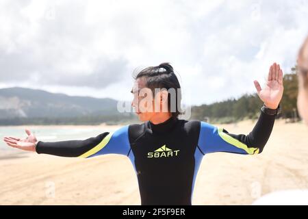 (210326) -- SANYA, 26 marzo 2021 (Xinhua) -- Foto scattata il 27 febbraio 2021 mostra Yang Xingfu che insegna il surf ai suoi membri del club nel villaggio di Tenghai a Sanya, nella provincia di Hainan della Cina meridionale. Il villaggio di Tenghai, un tempo un piccolo villaggio di pescatori, è diventato un famoso campo da surf dal boom del surf in Cina, dopo il surf ufficialmente ammesso nel programma dei Giochi Olimpici di Tokyo del 2020. Situato a Sanya, la provincia di Hainan della Cina meridionale, il villaggio ha anche vinto il riconoscimento per la sua grande combinazione di sport acquatici e industria turistica. Yang Xingfu, un abitante locale, è uno dei primi surfisti a Tenghai. Foto Stock