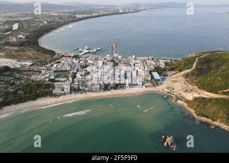 (210326) -- SANYA, 26 marzo 2021 (Xinhua) -- Foto aerea scattata il 25 febbraio 2021 mostra gli appassionati di surf che praticano il surf nel villaggio di Sanya, nella provincia di Hainan della Cina meridionale. Il villaggio di Tenghai, un tempo un piccolo villaggio di pescatori, è diventato un famoso campo da surf dal boom del surf in Cina, dopo il surf ufficialmente ammesso nel programma dei Giochi Olimpici di Tokyo del 2020. Situato a Sanya, la provincia di Hainan della Cina meridionale, il villaggio ha anche vinto il riconoscimento per la sua grande combinazione di sport acquatici e industria turistica. Yang Xingfu, un abitante locale, è uno dei primi surfisti a Tenghai. Sì Foto Stock