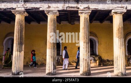 Murshidabad, Bengala Occidentale, India - Gennaio 2018: Turisti che camminano attraverso un colonnato in un antico palazzo rustico nella città vecchia di Murshidabad. Foto Stock