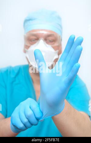 Il medico indossa guanti sterili. Preparazione all'intervento chirurgico Foto Stock