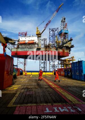 la nave di rifornimento offshore si avvicina lentamente alla macchina petrolifera durante la zona di 500 metri alla macchina petrolifera per la fornitura di carichi Foto Stock
