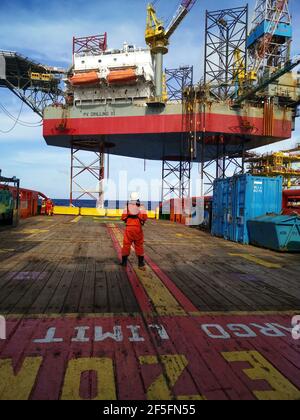 la nave di rifornimento offshore si avvicina lentamente alla macchina petrolifera durante la zona di 500 metri alla macchina petrolifera per la fornitura di carichi Foto Stock