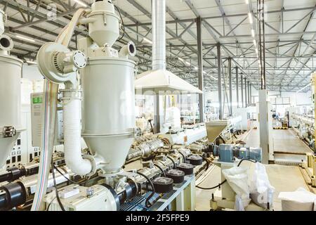 Officina con estrusori per la produzione di tubi in plastica. Linea di estrusione ad alta velocità di impianti idrici e tubi per gas. Stabilimento di produzione. Foto Stock