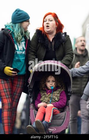 Anti-lockdown e anti Covid-19 vaccinazione protesta, Londra, 20 marzo 2021. Un bambino che soffia un fischio in un gramone. Foto Stock