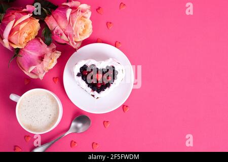 Torta da dessert romantica per San Valentino con rose. Biscotti dolci con crema e cuore rosso per un arredo rosa. Primo piano, spazio per la copia. Foto Stock