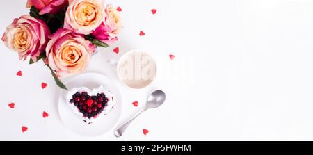 Torta da dessert romantica per San Valentino con rose. Biscotti dolci con crema e cuore rosso per un arredo bianco. Disposizione piatta. Banner. Vi Foto Stock